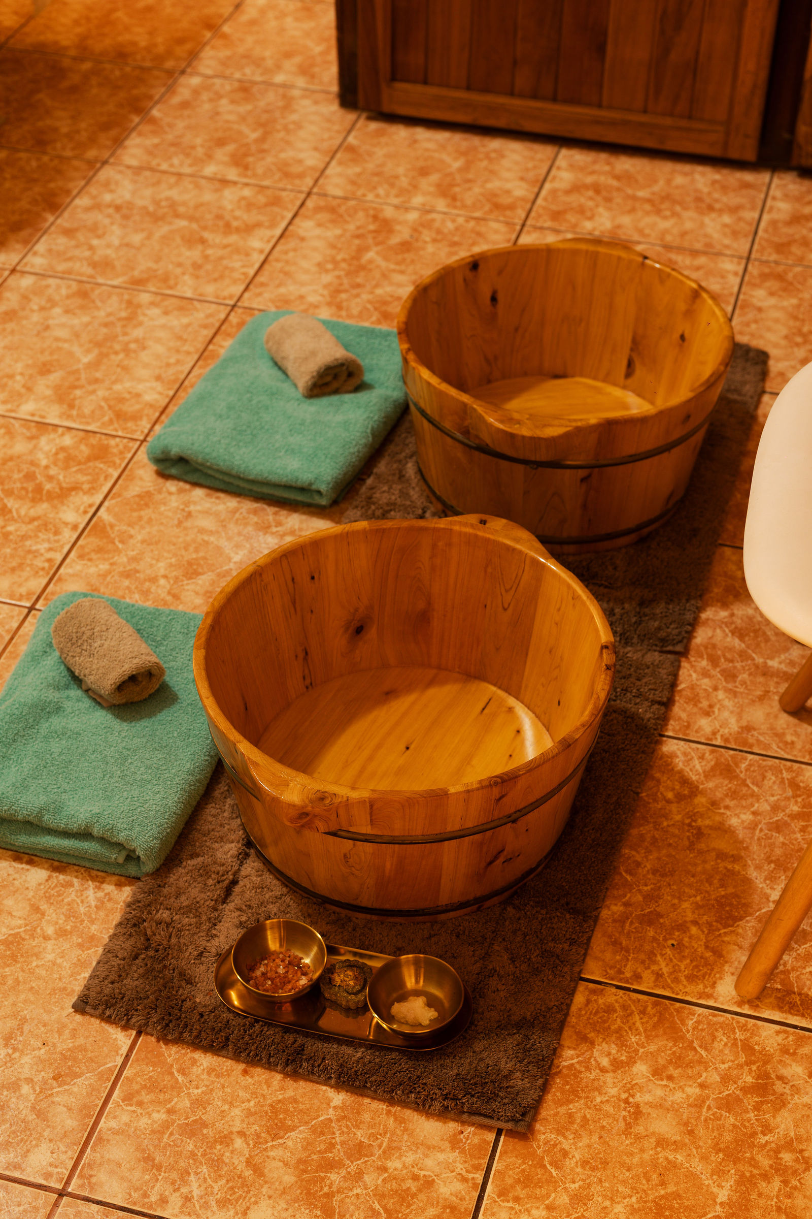 Wooden foot-bath buckets with towels and aromatic salts