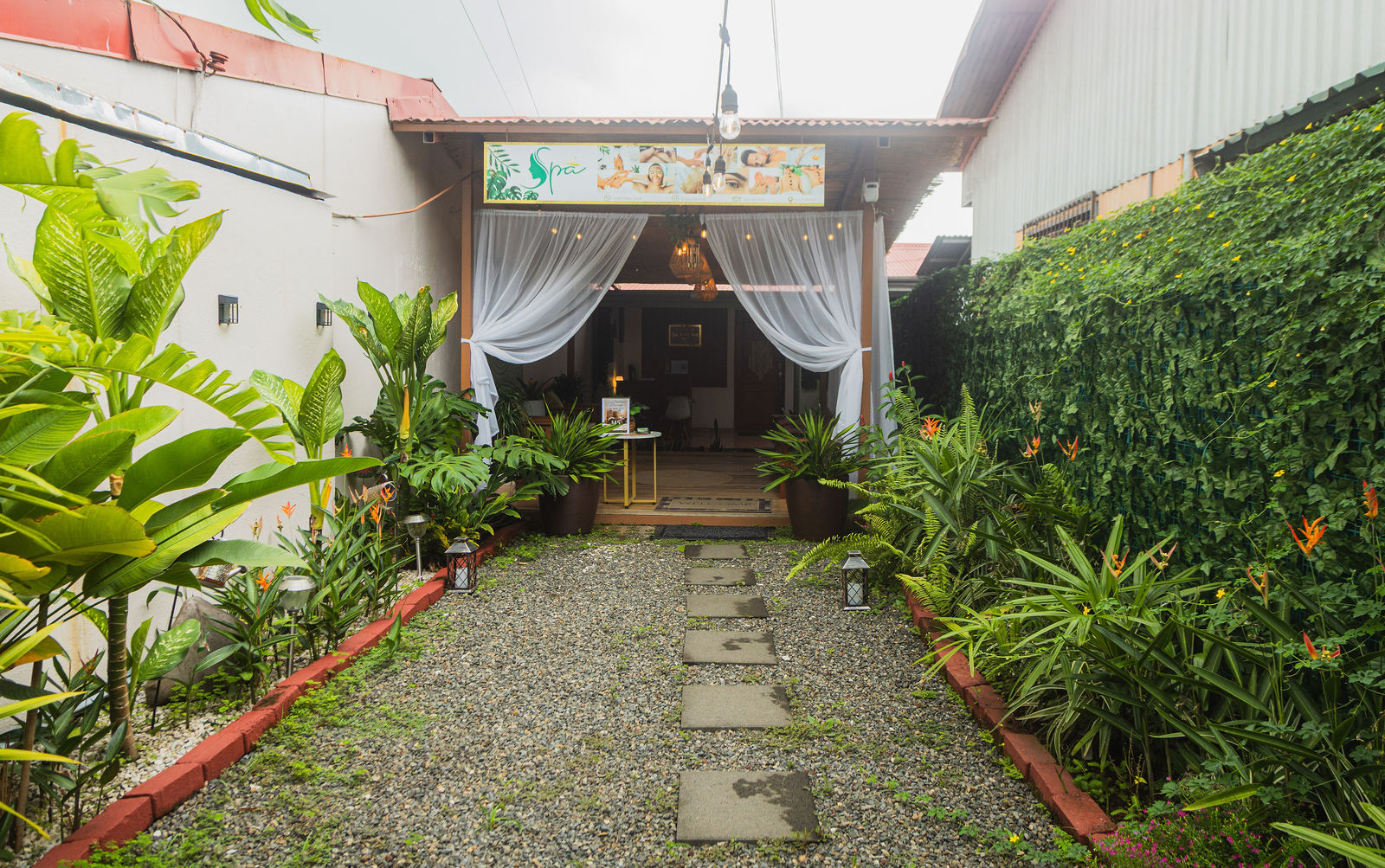 Tropical garden path leading to the spa's white-draped entrance