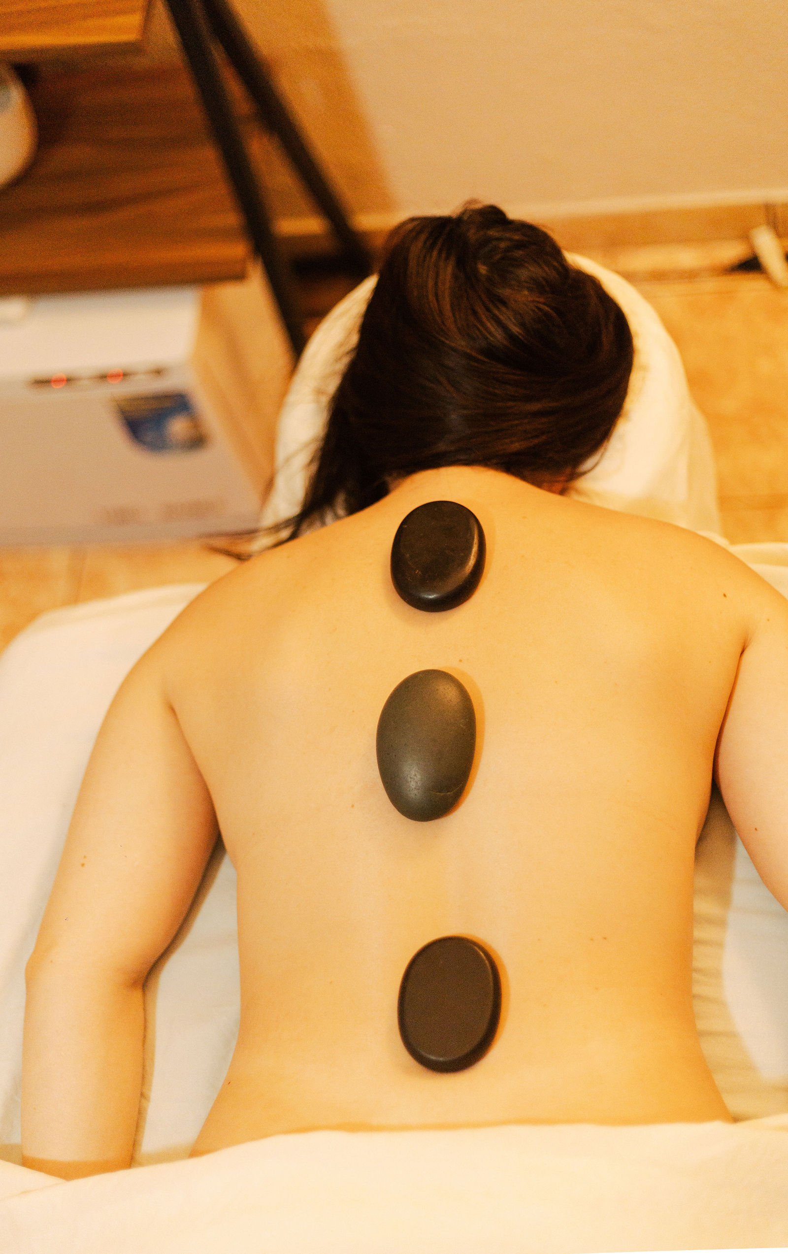 Hot volcanic stones aligned along the spine during a massage
